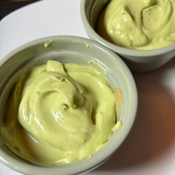 A bowl of creamy avocado mint pudding garnished with fresh mint leaves.