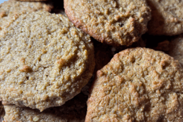 Close-up of soft pistachio cookies with golden edges and a slightly rustic texture, made with raw pistachios, almond flour, and honey