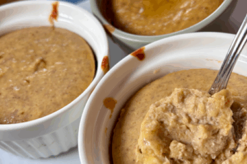 Pumpkin Cheesecake Cups in ramekins, one with a spoonful taken out