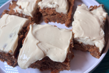 SCD carrot cake bars with yogurt cream cheese frosting on a white plate, showing the moist grain-free bars topped with thick creamy frosting