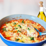 Grain-free pizza beans baked with tomato sauce, bell peppers, melted cheese, and fresh basil in a blue skillet.